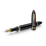 Black fountain pen with gold trim and a gold-toned nib, cap posted on the back of the barrel, shown at an angle on a white